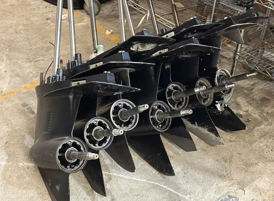 Outboard lower units and props staged for condition review